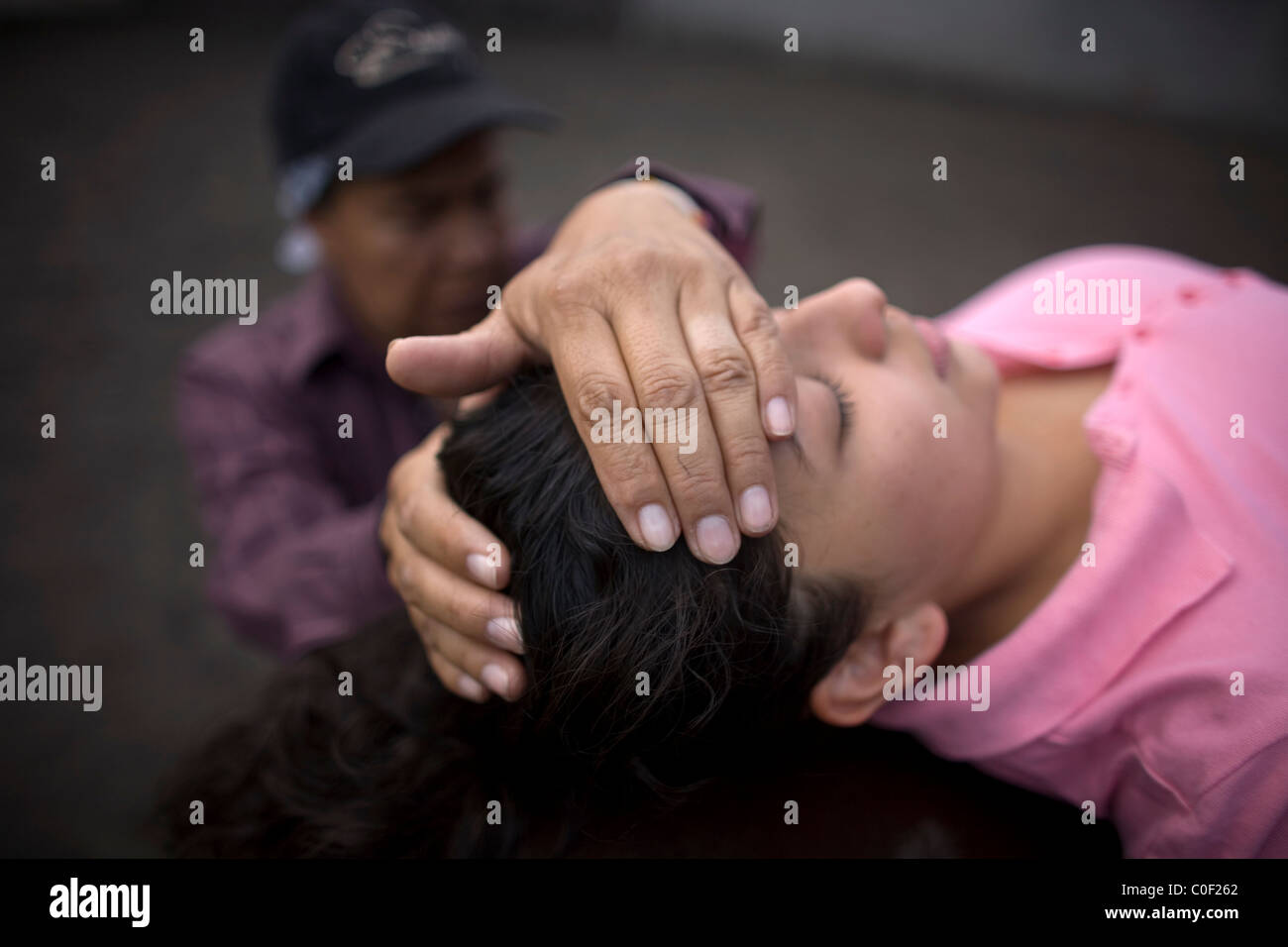 Equine Therapeut Guadalupe Pena umfasst den Kopf einer Frau, die unter Stress leidet, da sie auf dem Rücken eines Pferdes während h liegt Stockfoto