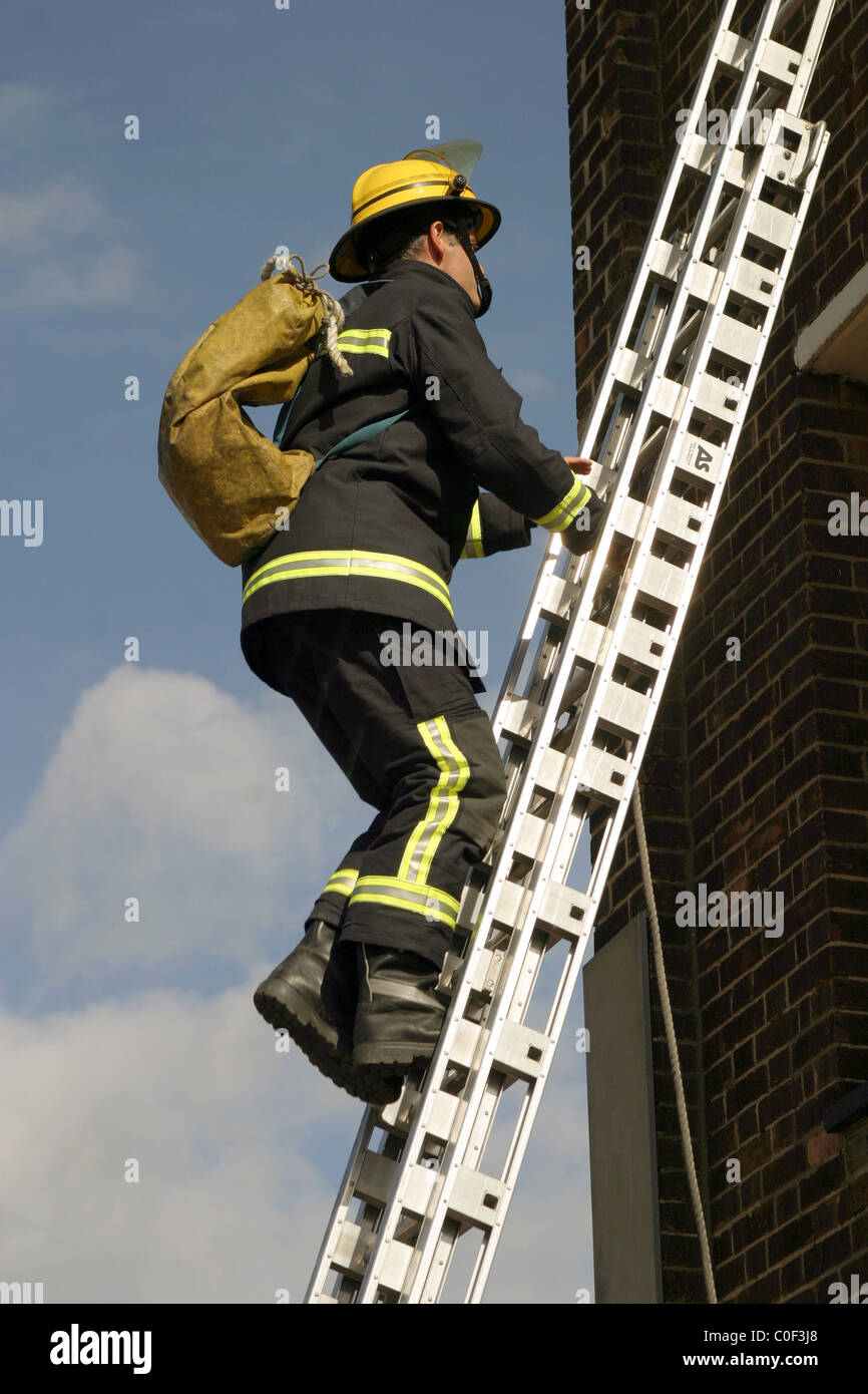 ECFRS Feuerwehr Feuerwehrmann klettert eine Leiter Stockfoto