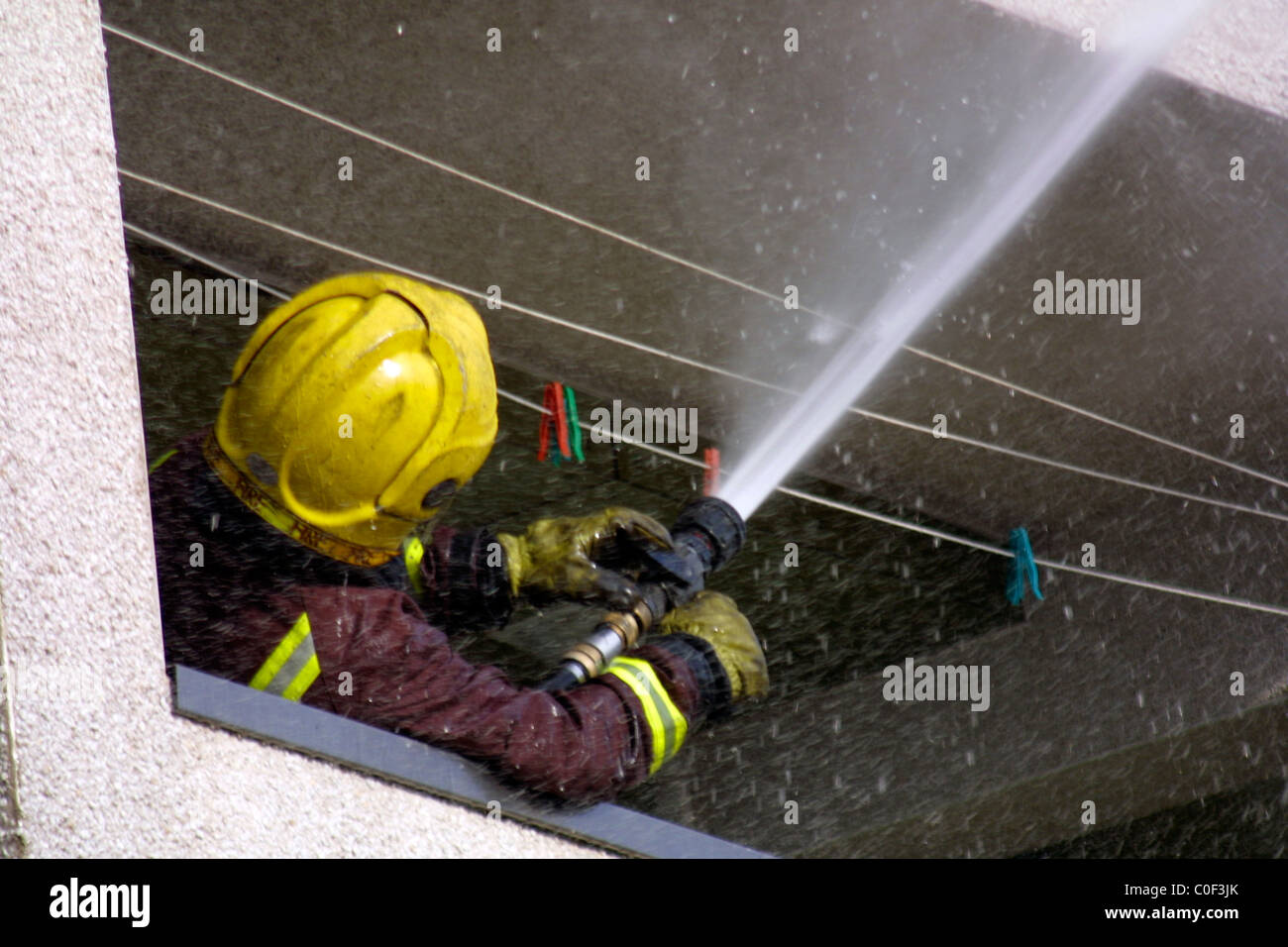 London-Feuerwehrmann verwendet einen Schlauch bei Szene eines Feuers Stockfoto