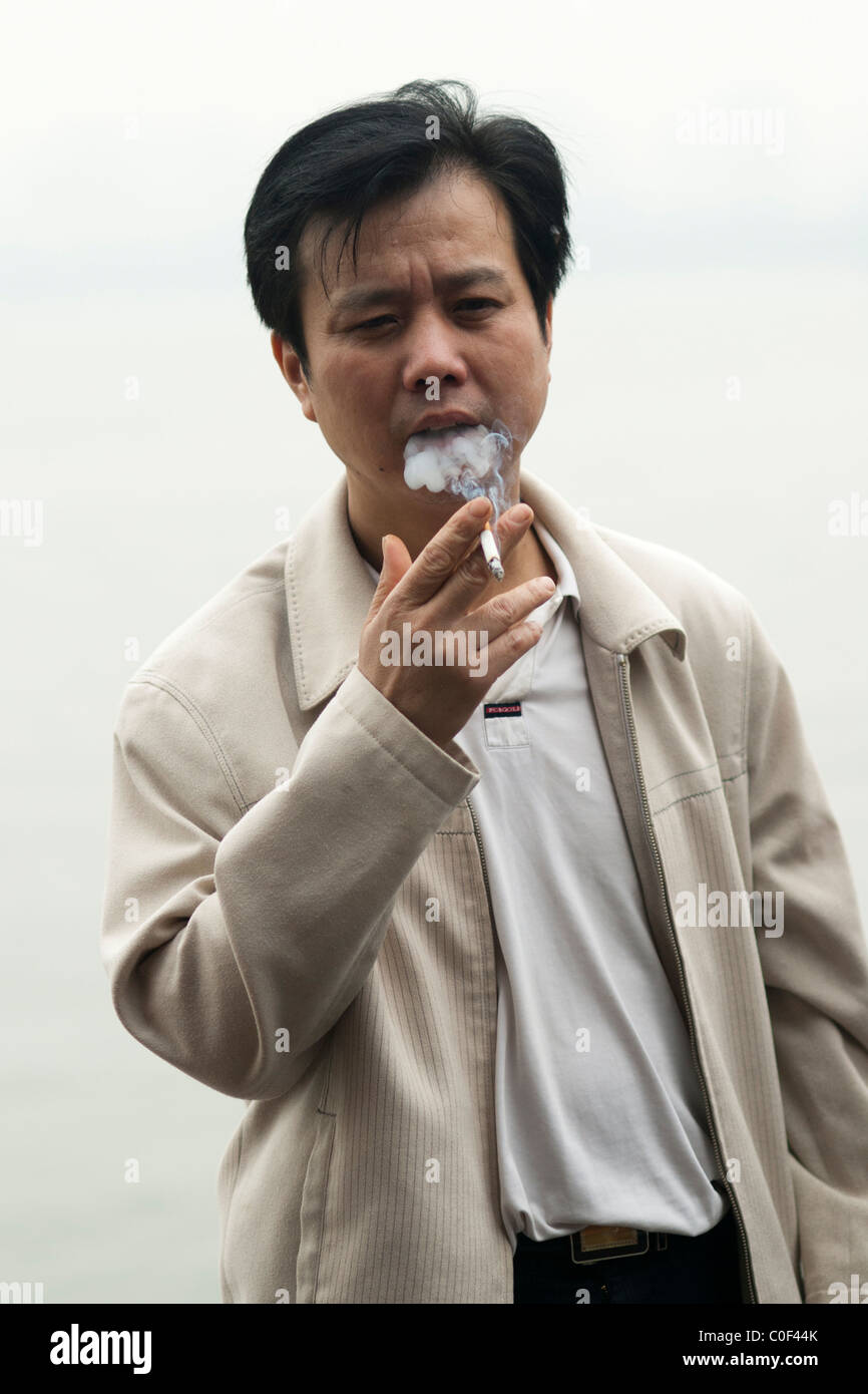 Chinesischer Mann raucht eine Zigarette Stockfoto