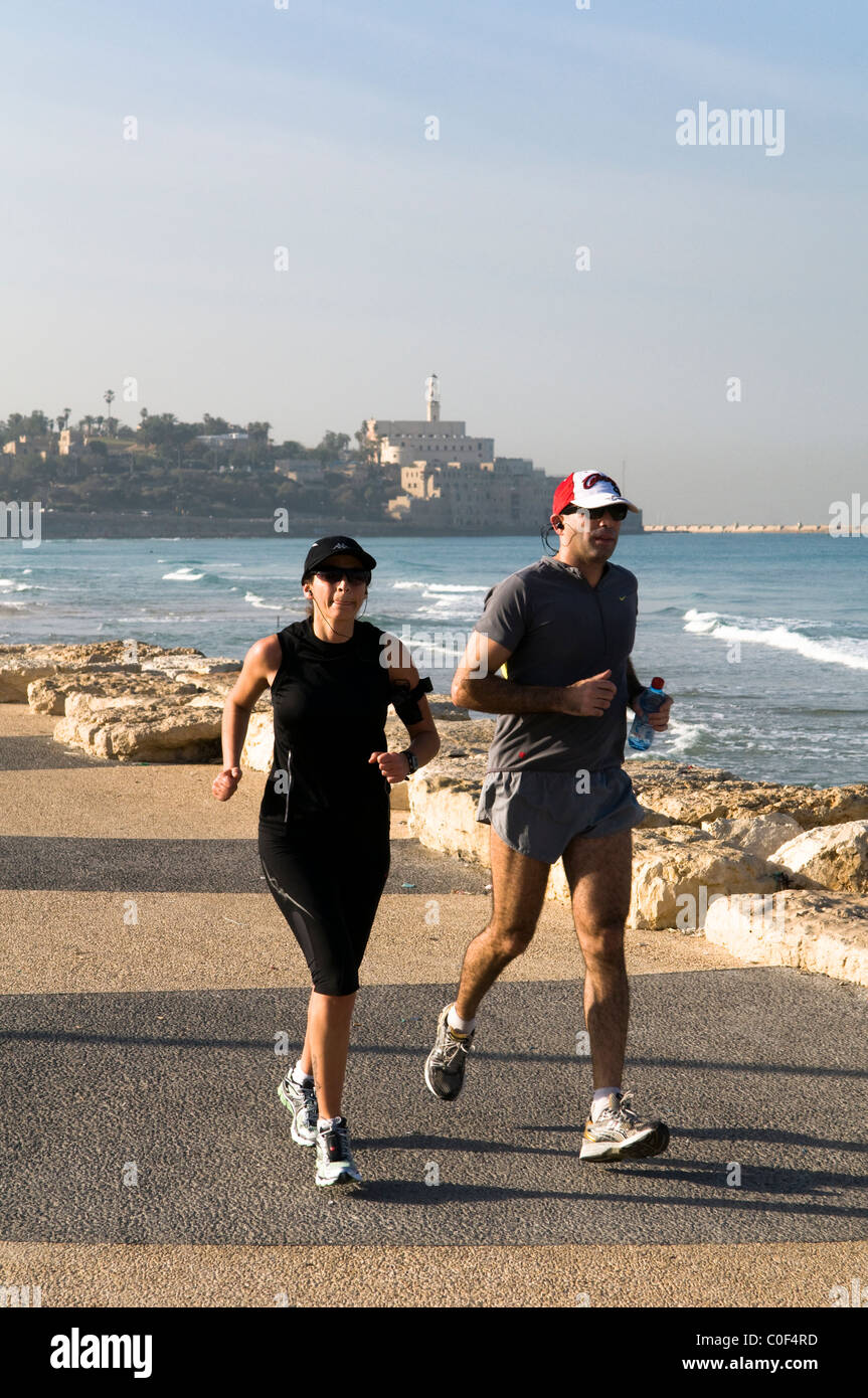Joggen auf der schönen Promenade am Mittelmeer in Tel Aviv. (Jaffa im Hintergrund) Stockfoto