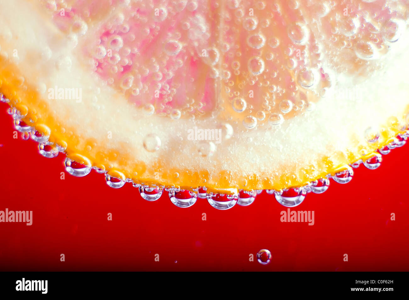 Close-up Zitrone mit Luftblasen auf rot Stockfoto