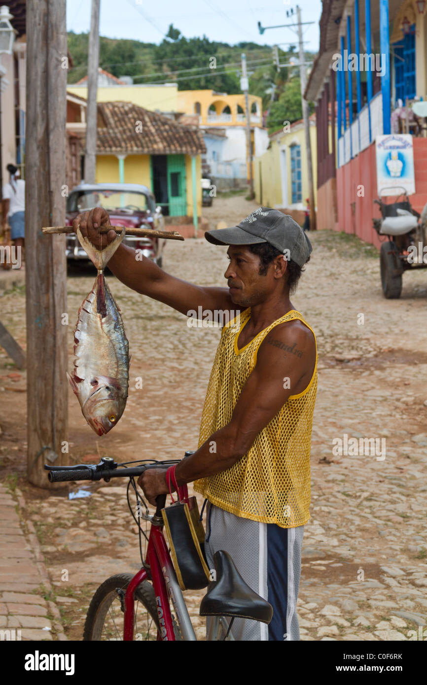 Mann mit einem Fisch, Straße mit Kopfsteinpflaster, Oldtimer, Trinidad Kuba Stockfoto
