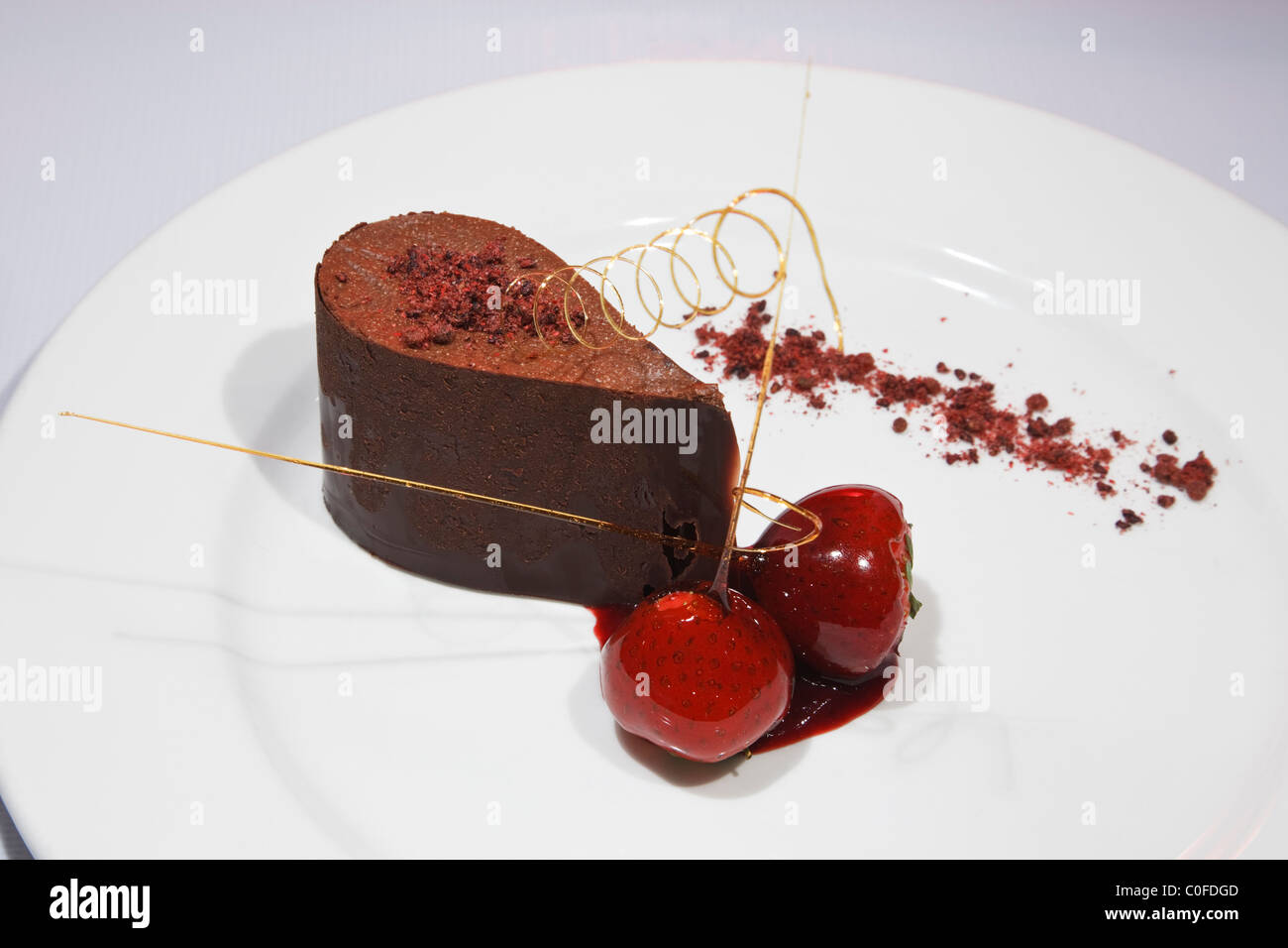 Schokoladenmousse mit zwei Erdbeeren Gourmet-Dessert Kurs auf einem weißen Teller von oben Stockfoto