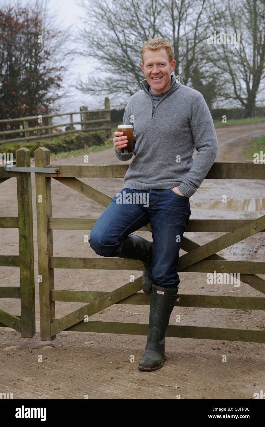 Halten ein Glas Bier Adam Henson Landwirt und TV-Moderatorin zu Hause auf seinem Hof Gloucestershire in den Cotswolds-England Stockfoto