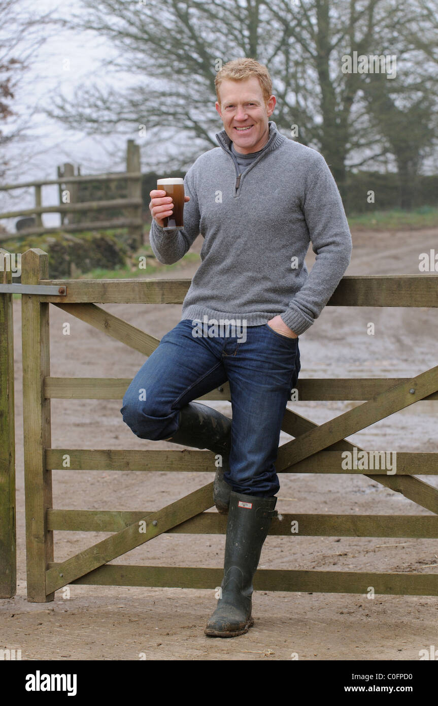 Halten ein Glas Bier Adam Henson Landwirt und TV-Moderatorin zu Hause auf seinem Hof Gloucestershire in den Cotswolds-England Stockfoto