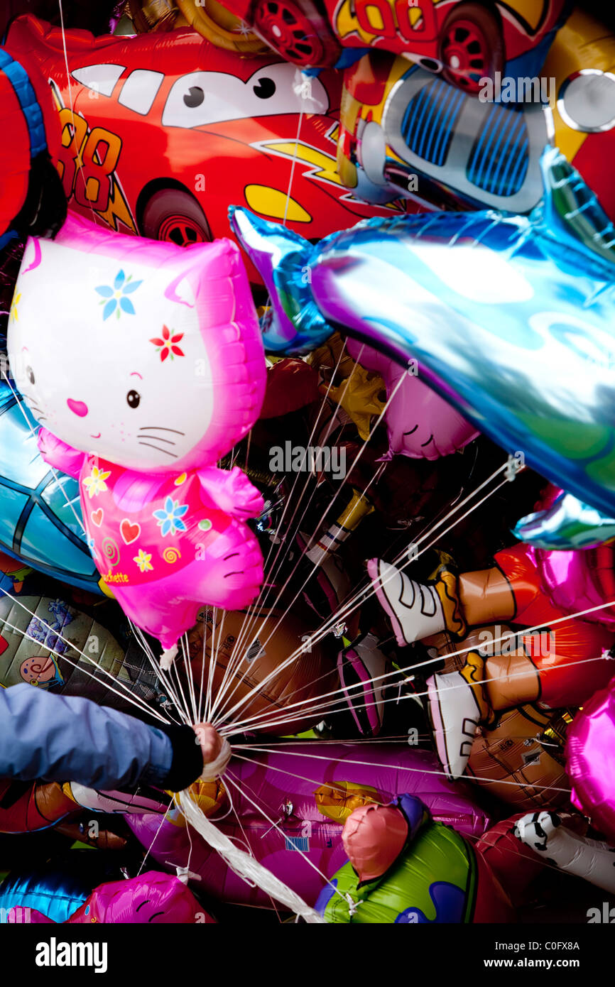 Helium-Ballon-Tiere und Autos in einer Hand gehalten, ein Haufen, Festivalparty Stockfoto