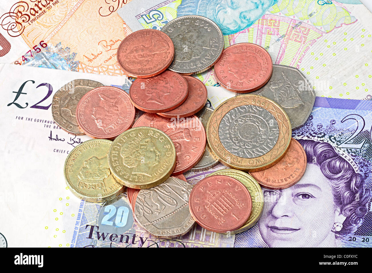 Auswahl an zeitgenössischen britischen Münzen auf britische Banknoten Hintergrund Stockfoto