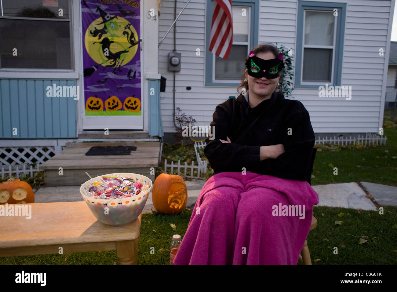Eine junge kostümierte Frau wartet auf Trick oder Treaters am späten Nachmittag an Halloween kommen. Stockfoto