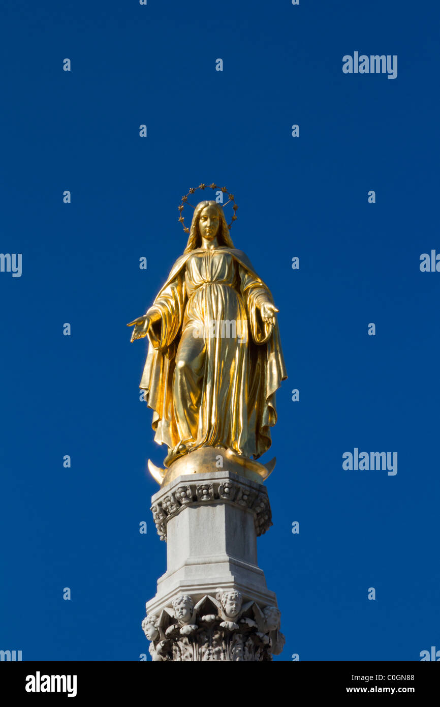 Jungfrau Maria Statue aus Gold vor blauem Himmel Stockfoto