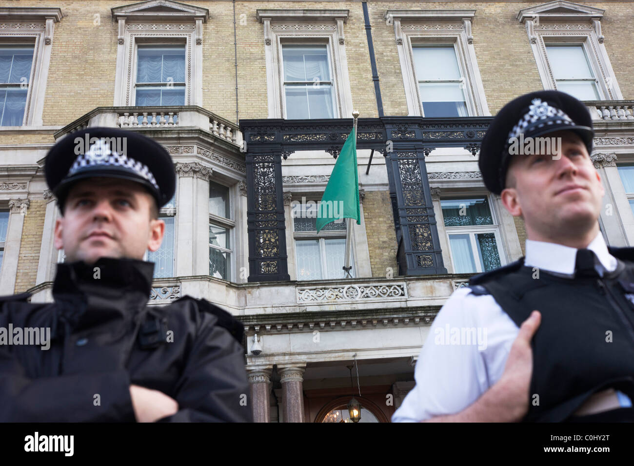 London Metropolitan Polizisten bewachen die Außenseite der libyschen Botschaft London, zu die noch die Pro-Gaddafi-Flagge fliegt. Stockfoto