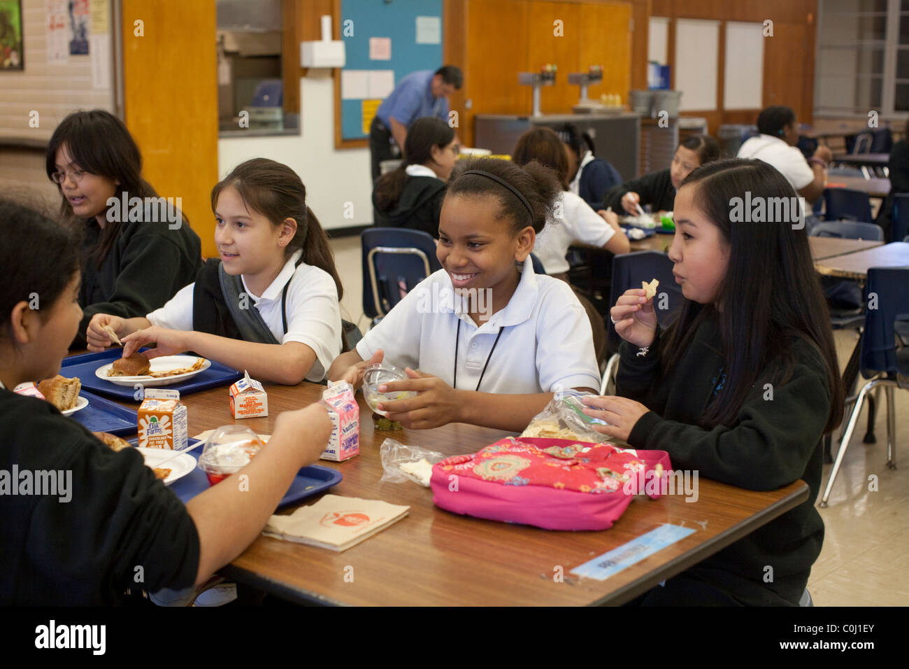 Mittelschule Mädchen knüpfen beim Mittagessen in der Cafeteria an der Ann Richards Schule für junge Frauen in Führungspositionen in Austin Texas Stockfoto