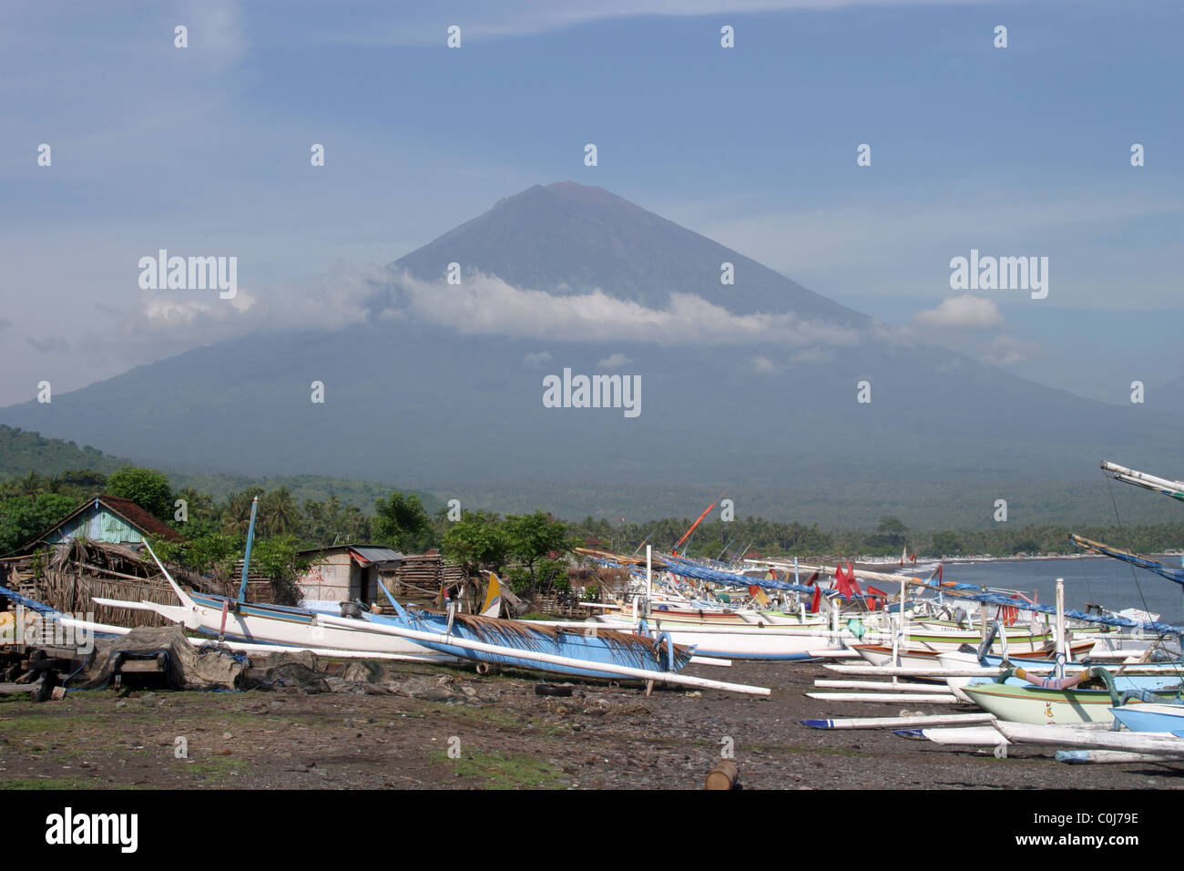 Reihe von Booten vor Vulkan auf Küste von Amed, Bali. Stockfoto