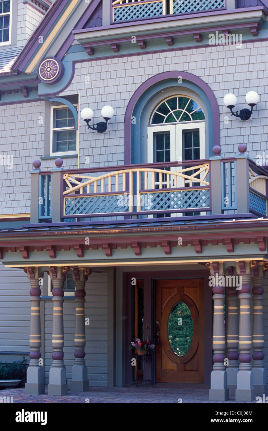 VOR DEM ÜBERDACHTEN EINGANG ZU VIKTORIANISCHEN "PAINTED LADY" HAUS IN EINEM VORORT VON MINNEAPOLIS, MINNESOTA BIETET KLEINEN BALKON. Stockfoto
