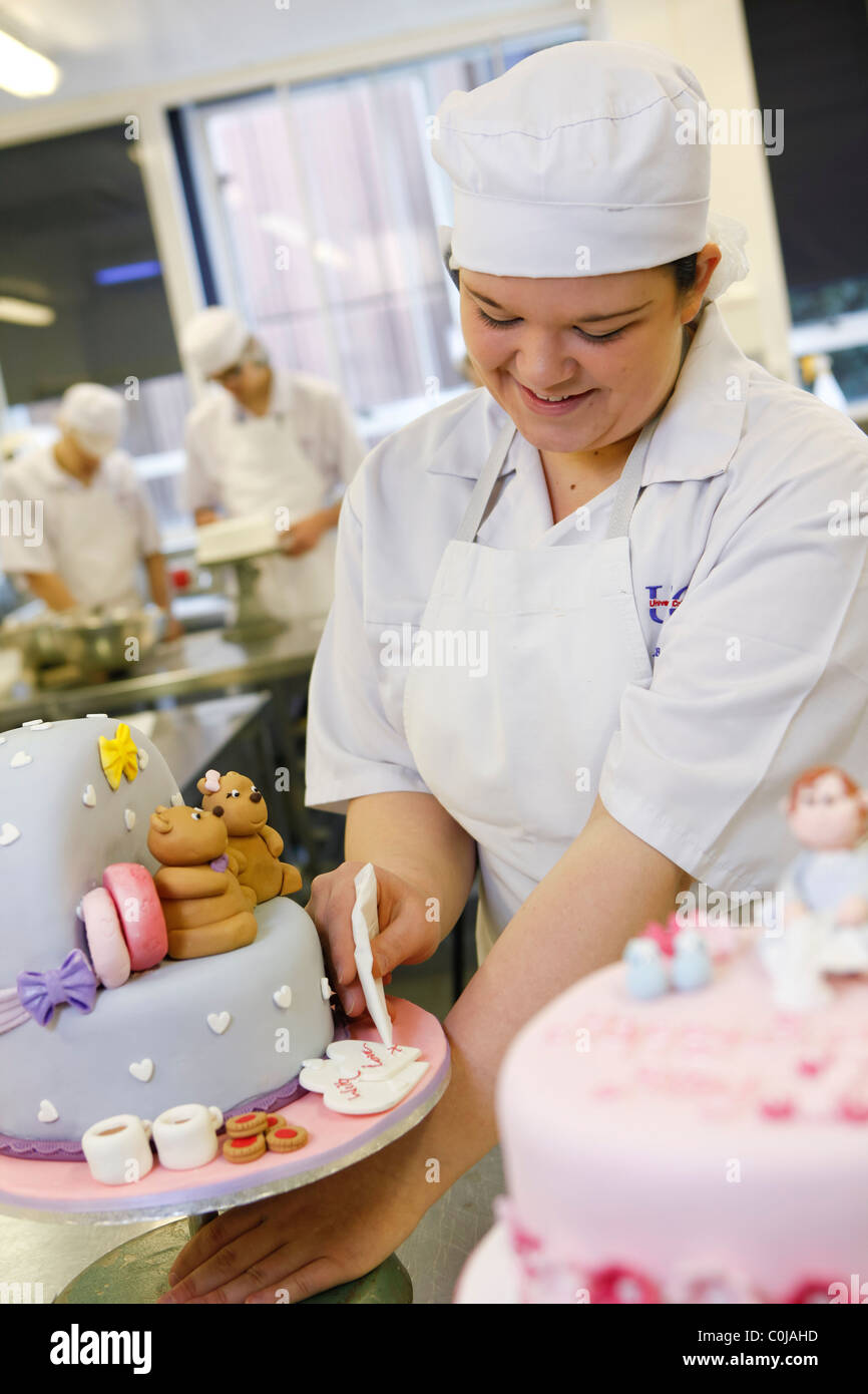 University College Birmingham bietet darüber hinaus höhere und postgraduale Weiterbildung. Köche, die lernen, wie man einen Kuchen Eis. Stockfoto