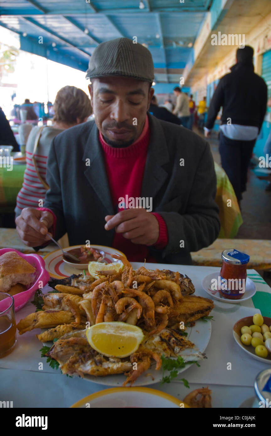 Lokale Mann essen Meeresfrüchte an der Marina Fisch Stände Souss Südafrika  Marokko Agadir Stockfotografie - Alamy