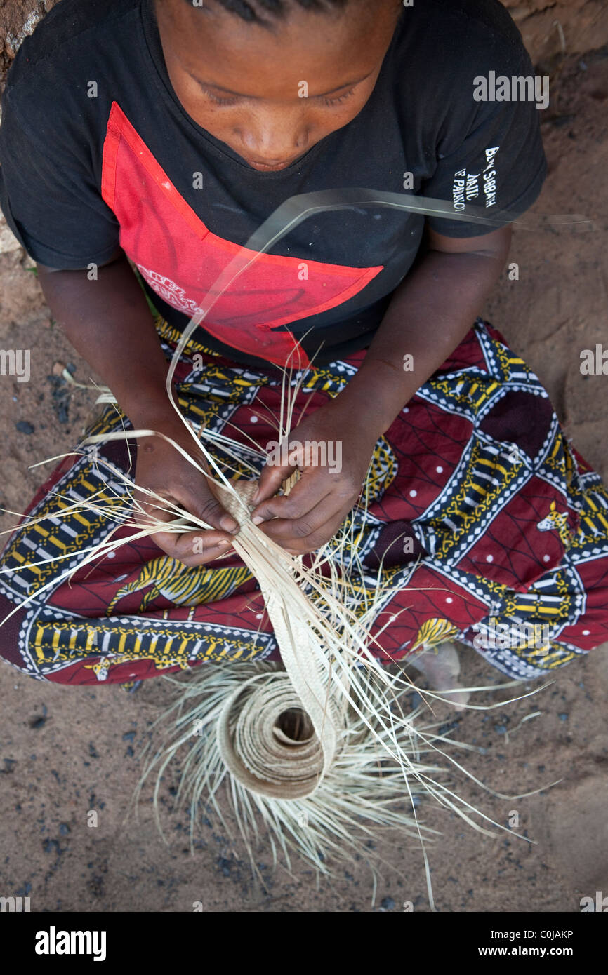 Eine erfahrene Frau spinnt einen Hut aus Stroh in Rufiji Bezirk, Tansania, Ostafrika. Stockfoto