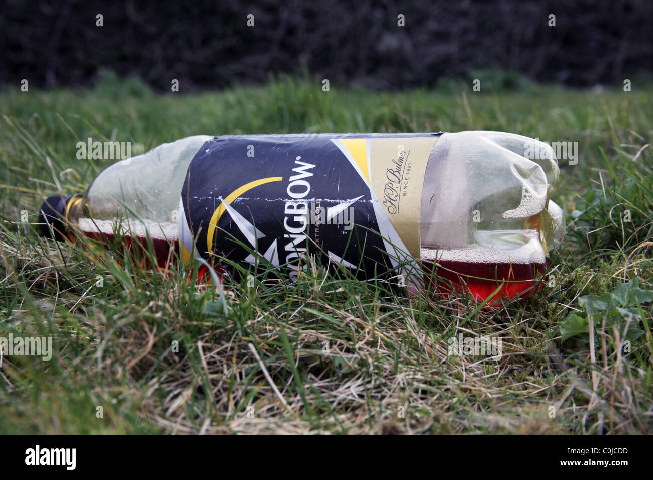 Getränke-Plastikflasche auf Grünstreifen verworfen Stockfoto