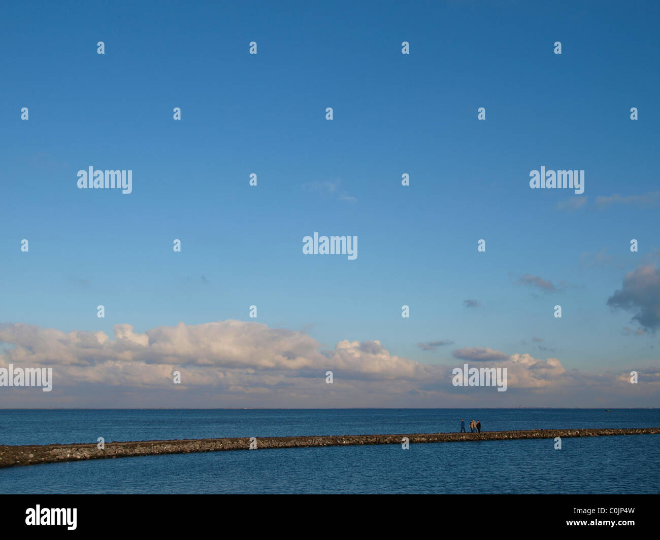Vier Personen zu Fuß entlang dem Deich der Oosterschelde Wasser Zeeland, Niederlande Stockfoto