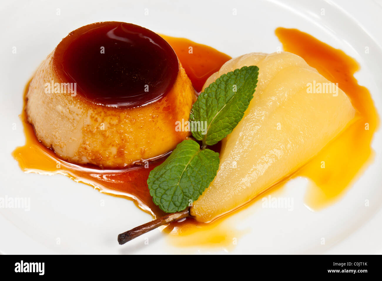 Kochs Präsentation Gerichte - Ingwer Crème Caramel; pochierte Birne. Stockfoto
