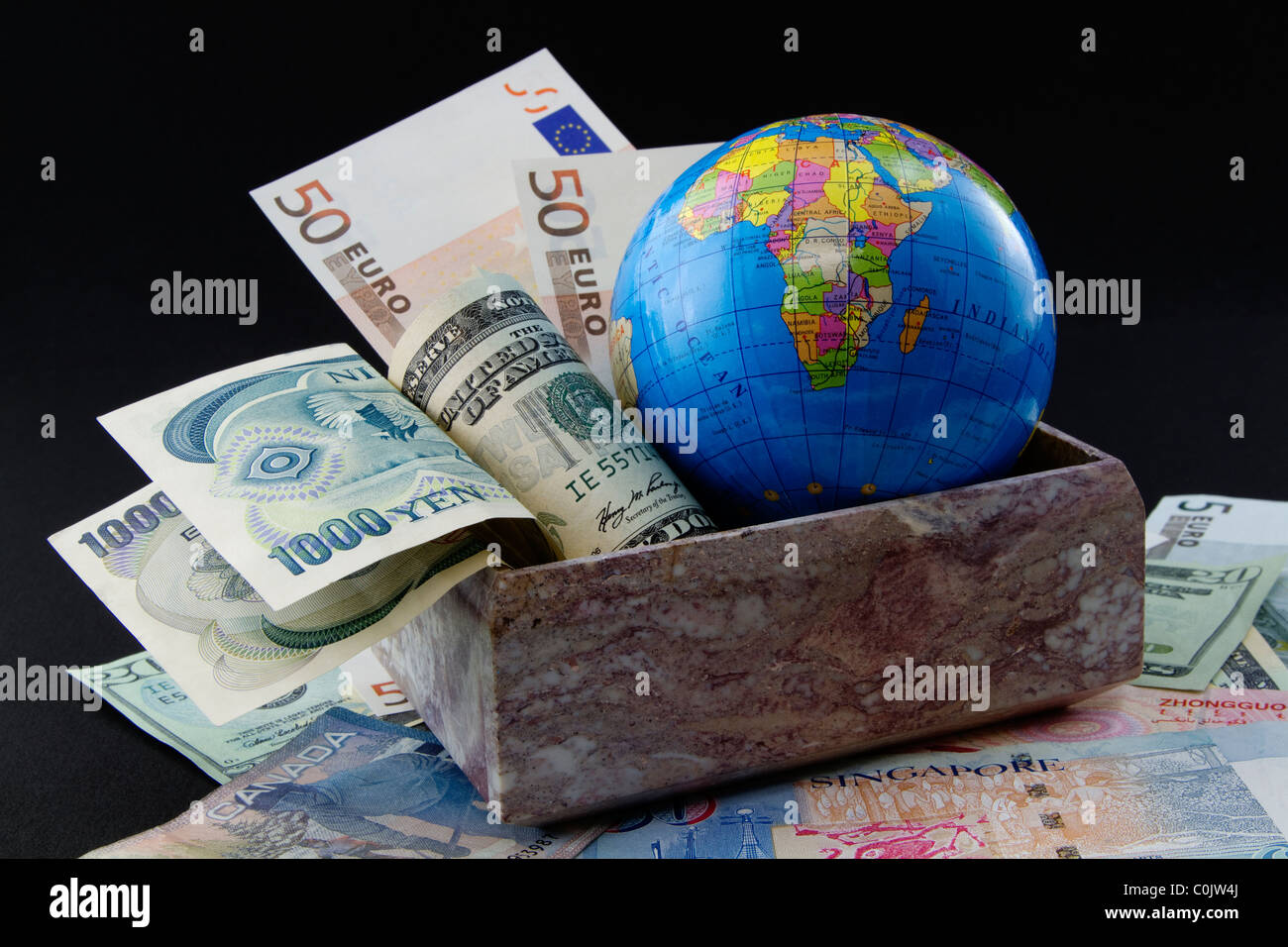 Globus mit Welt Währungen in Marmor-box und auf Weltwährung. Stockfoto