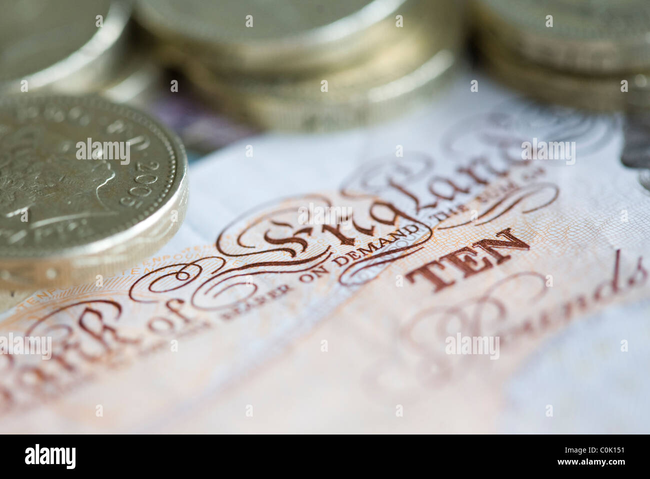 Zehn Pfund Sterling-Noten und ein Pfund-Münzen sind für ein Foto einrichten Stockfoto