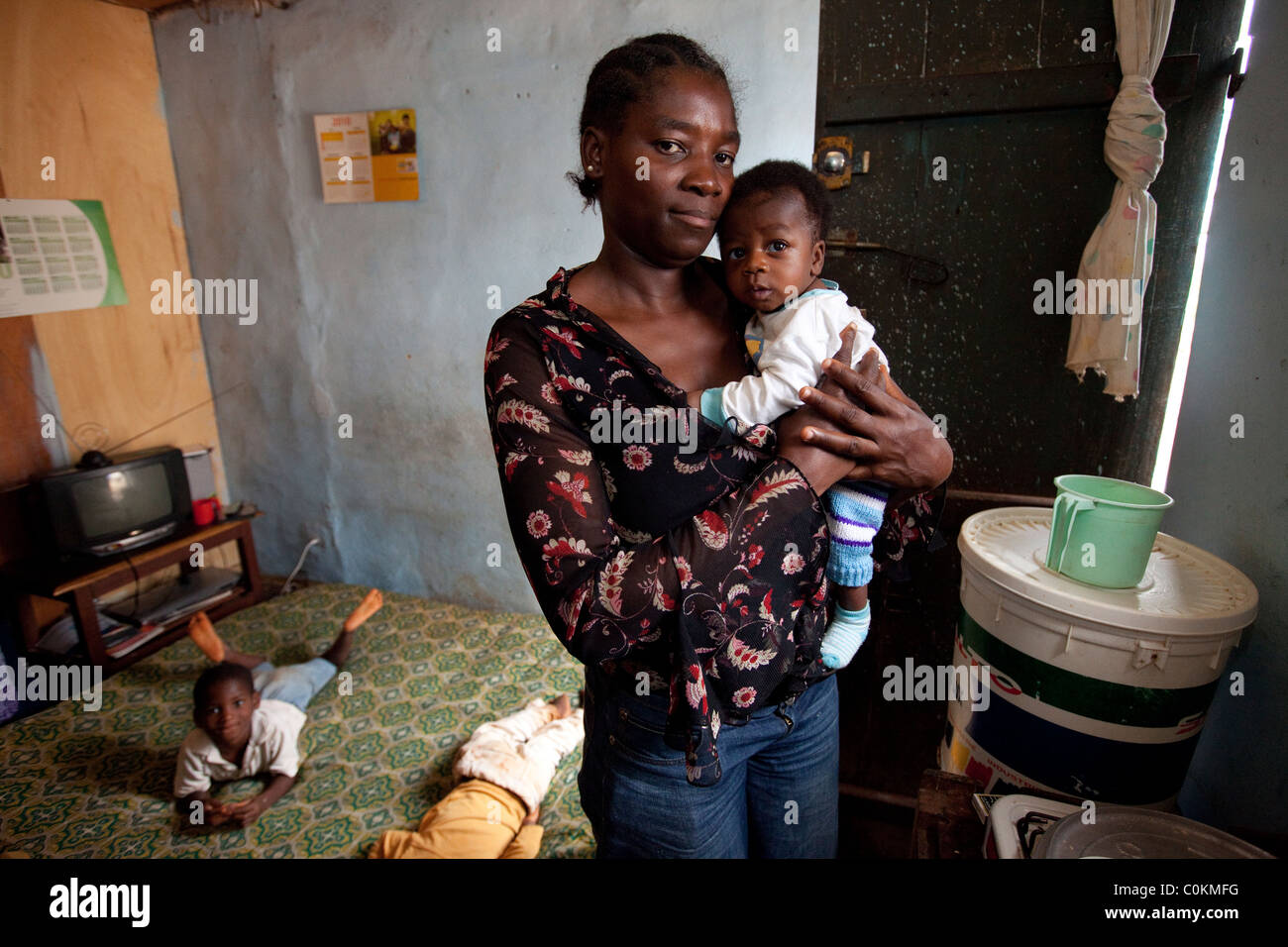 Eine junge alleinerziehende Mutter steht in ihrem Appartement mit 1 Schlafzimmer in Yaounde, Kamerun, Westafrika. Stockfoto