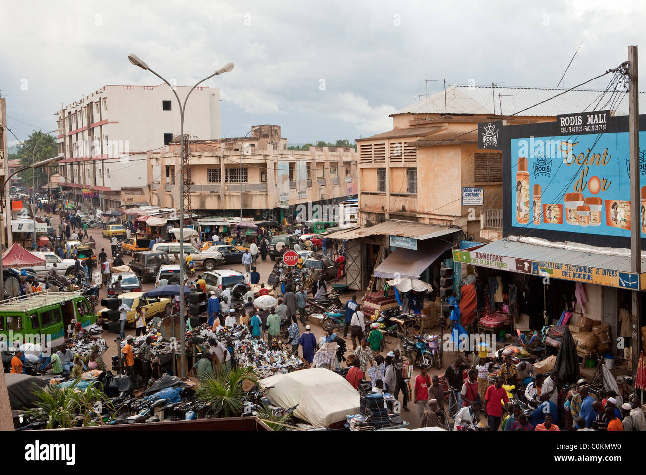 Autos, Motorräder und Fußgänger drängen sich auf die belebten Straßen von Bamako, Mali, Westafrika. Stockfoto