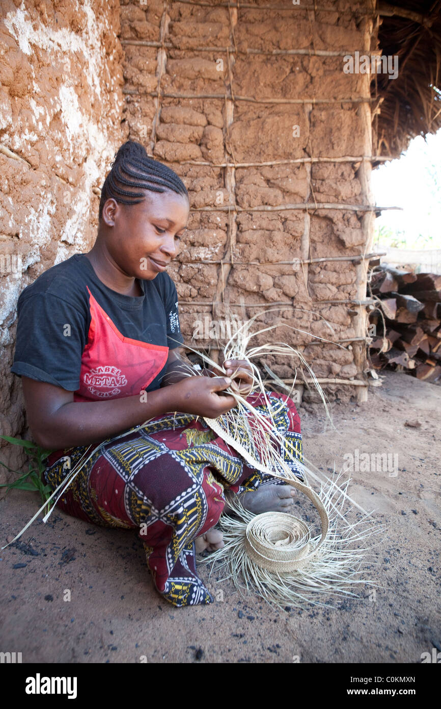 Eine erfahrene Frau spinnt einen Hut aus Stroh in Rufiji Bezirk, Tansania, Ostafrika. Stockfoto