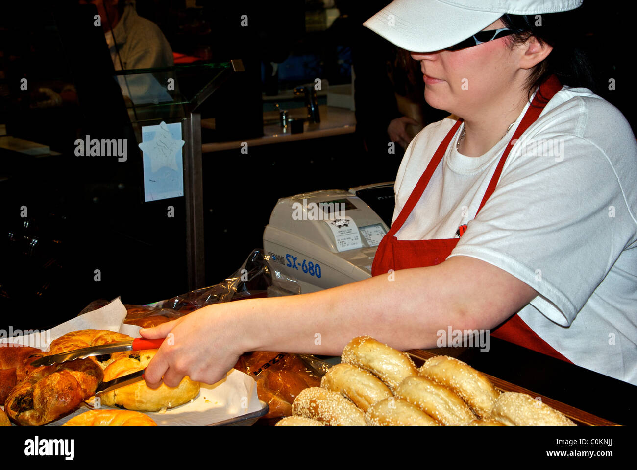 Verkäuferin serviert geräucherte Fleisch Gebäck Bagel Granville Island Börse Vancouver Stockfoto