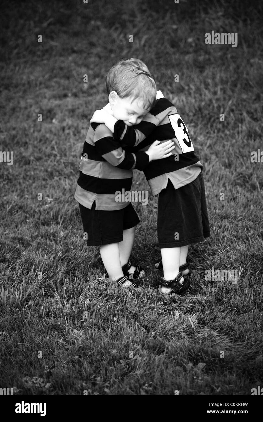 Twin Baby Boys umarmt in Rugby-Kleidung Stockfoto
