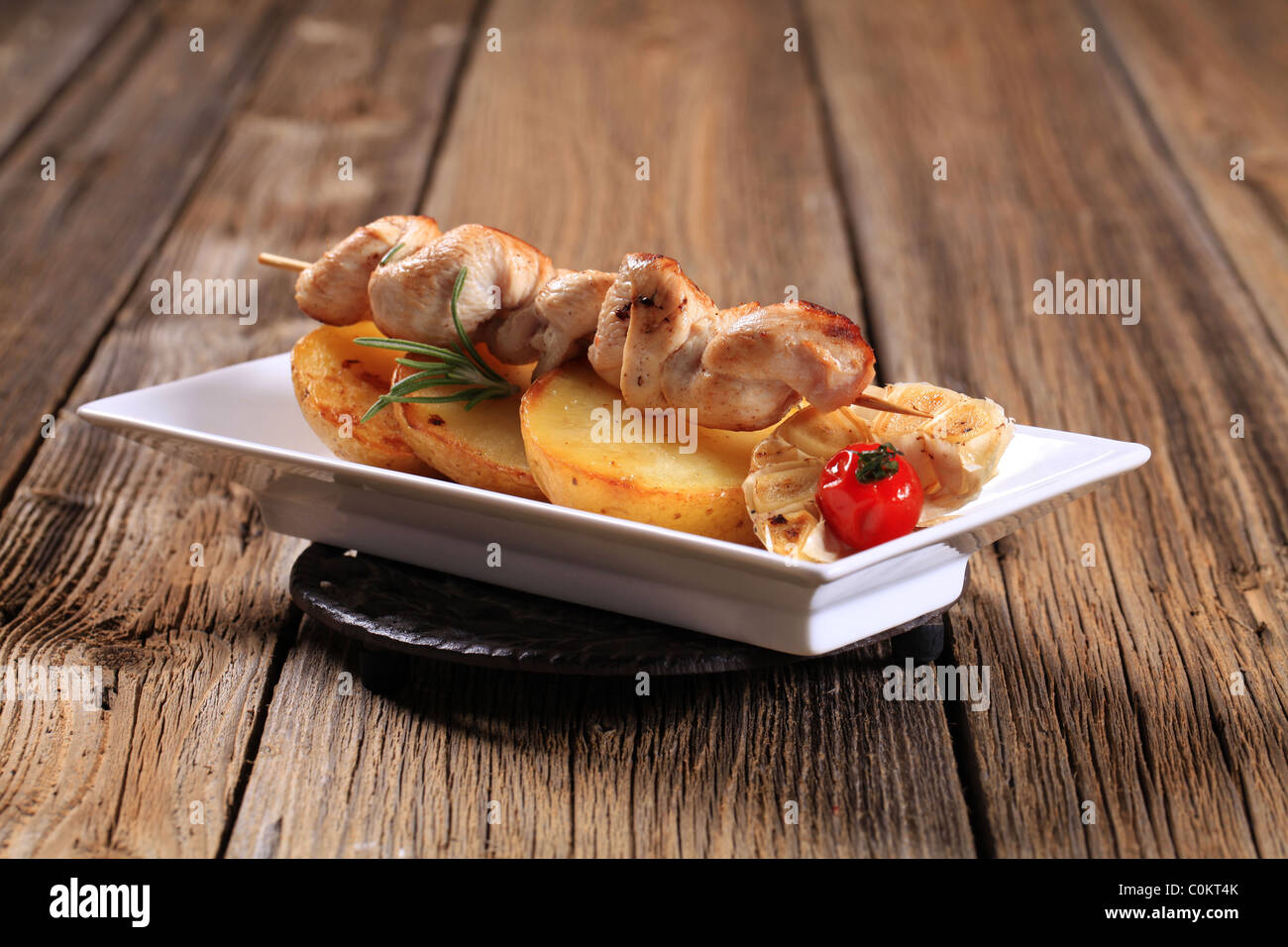 Chicken Kebab auf Pfanne gerösteten Kartoffelscheiben Stockfoto