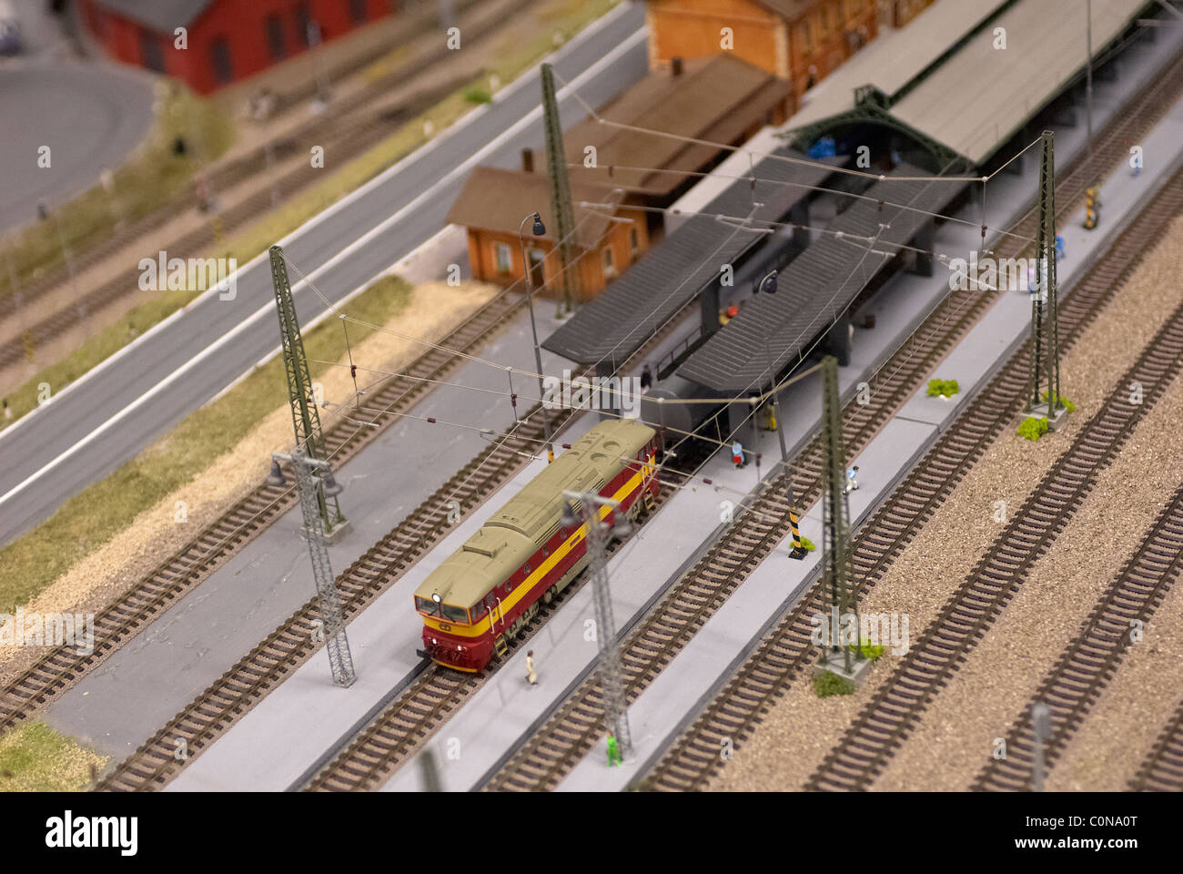 Detail des Modell Spielzeug Eisenbahn Bahnwerk mit Lok, Wagen, Gleise und Gebäude Stockfoto