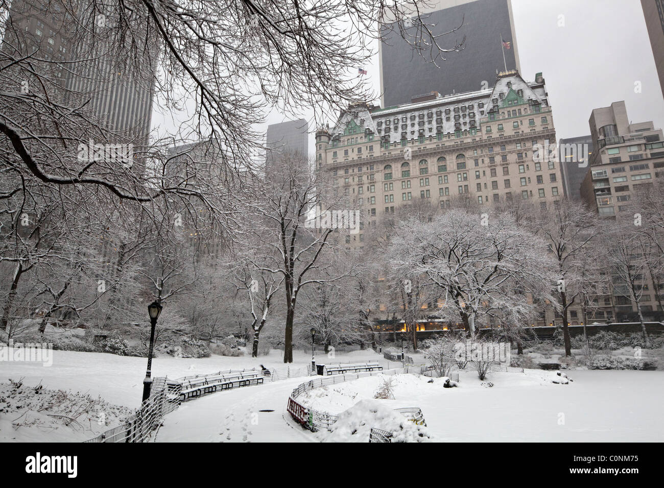 Central Park - New York City während der Schneesturm in den frühen Morgenstunden mit Plaza Hotel im Hintergrund Stockfoto