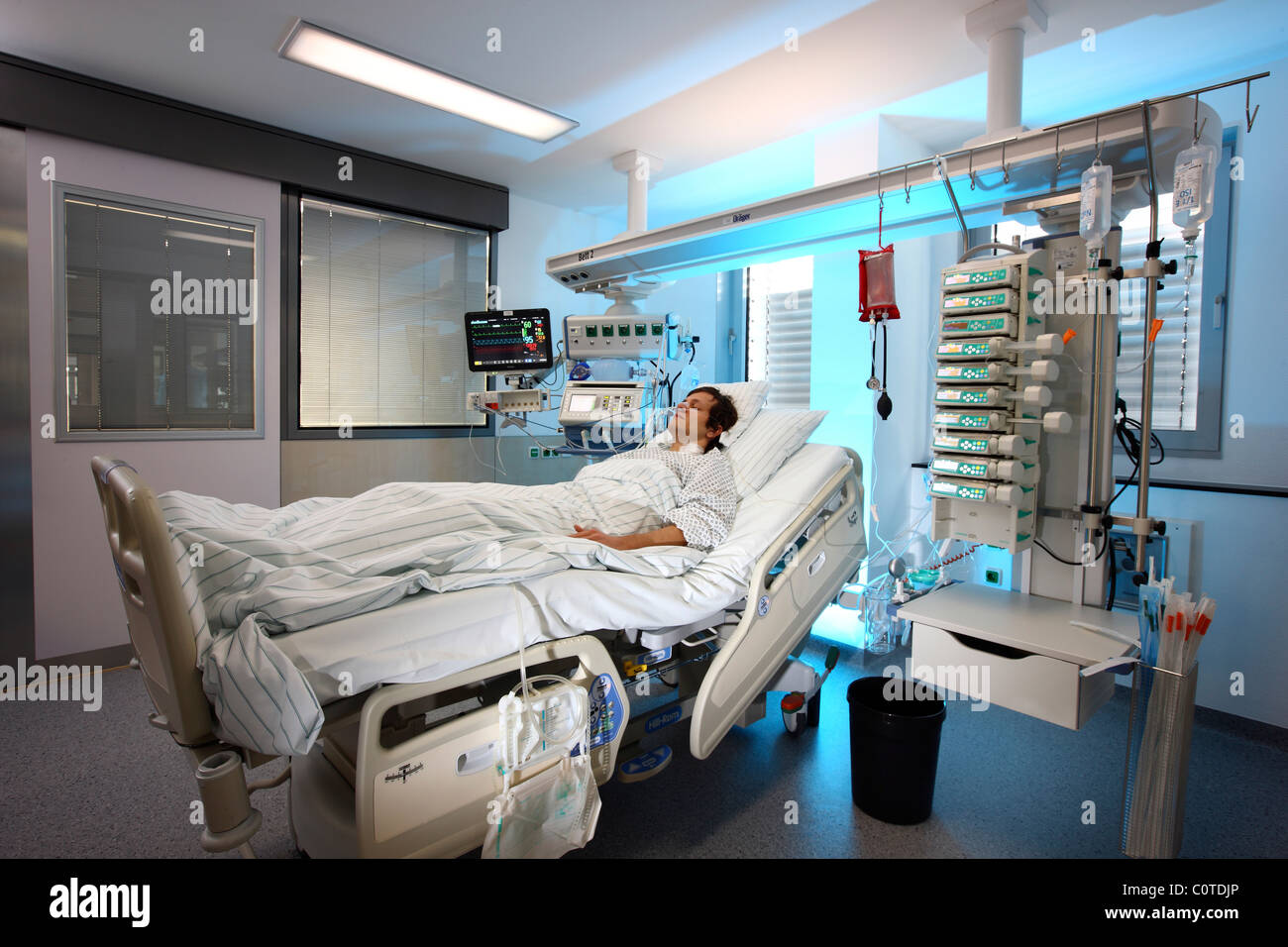Intensivstation in einem Krankenhaus. Ein Patient wird mit verschiedenen lebenserhaltenden Systemen verbunden. Stockfoto