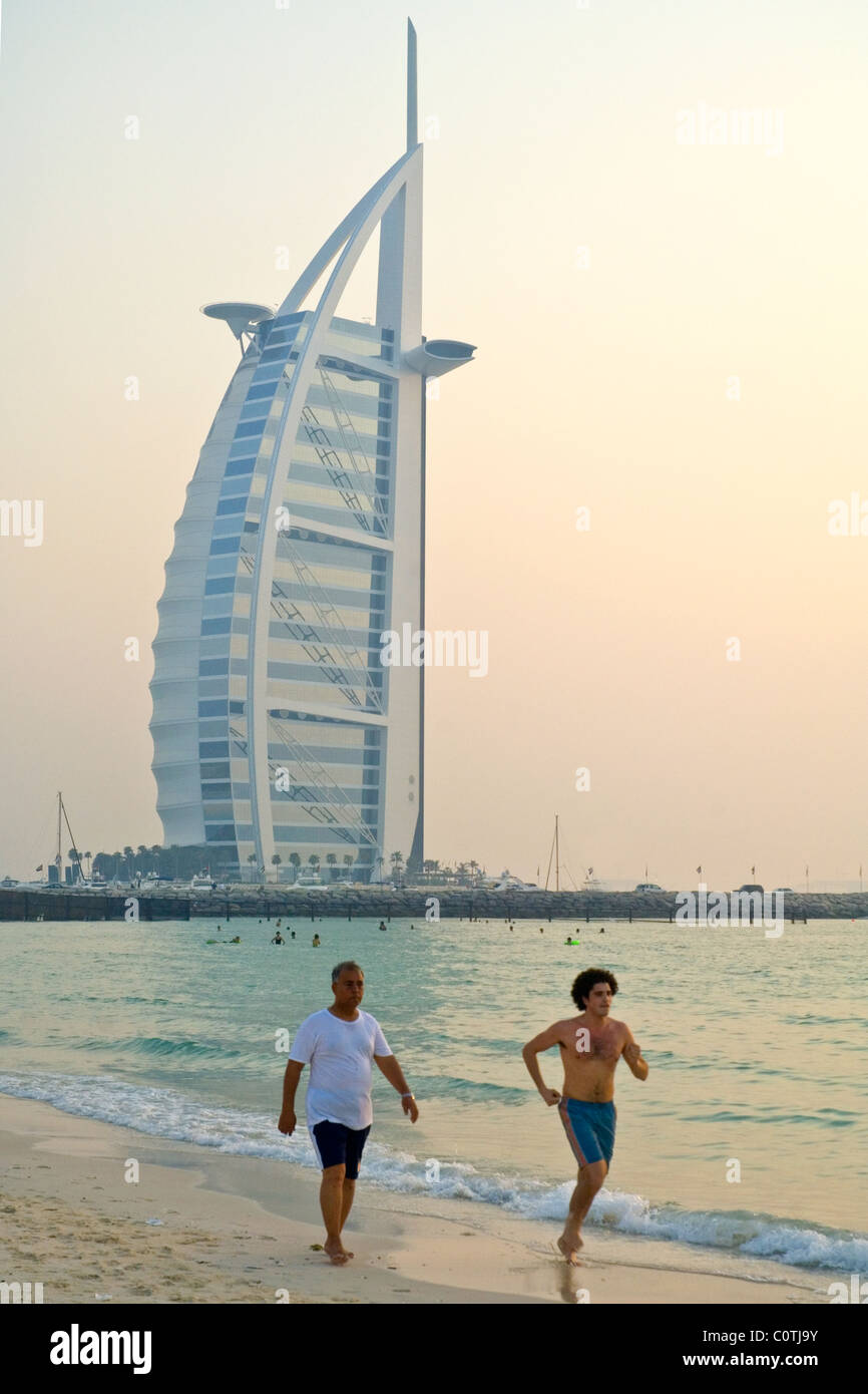 Jogger, die entlang des Strandes im Burj Al Arab Hotel Dubai United Arab Stockfoto