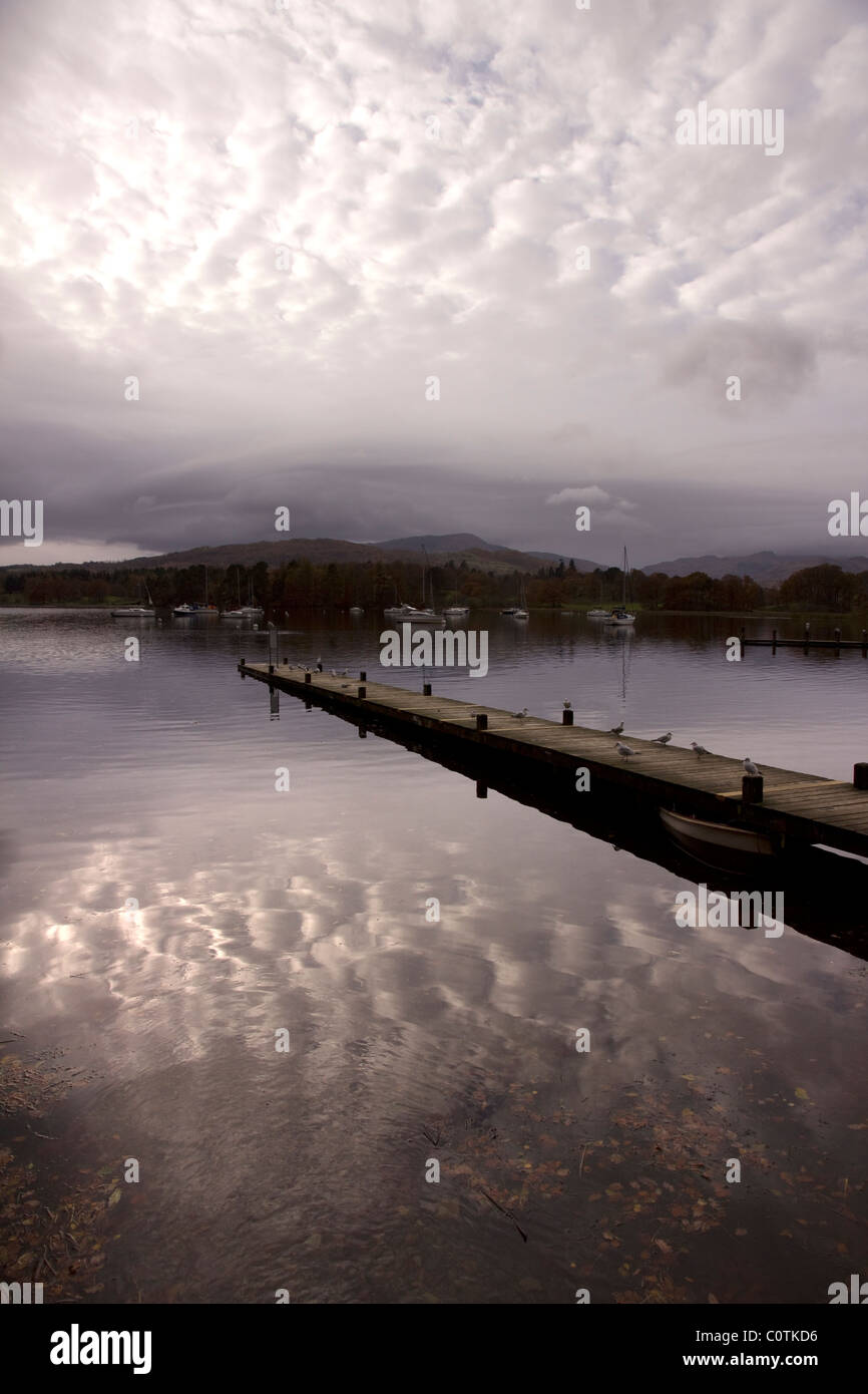 Bewölkter Himmel Reflexionen und Bootsanleger am Lake Windermere, Ambleside, Lake District, Cumbria, England, UK Stockfoto