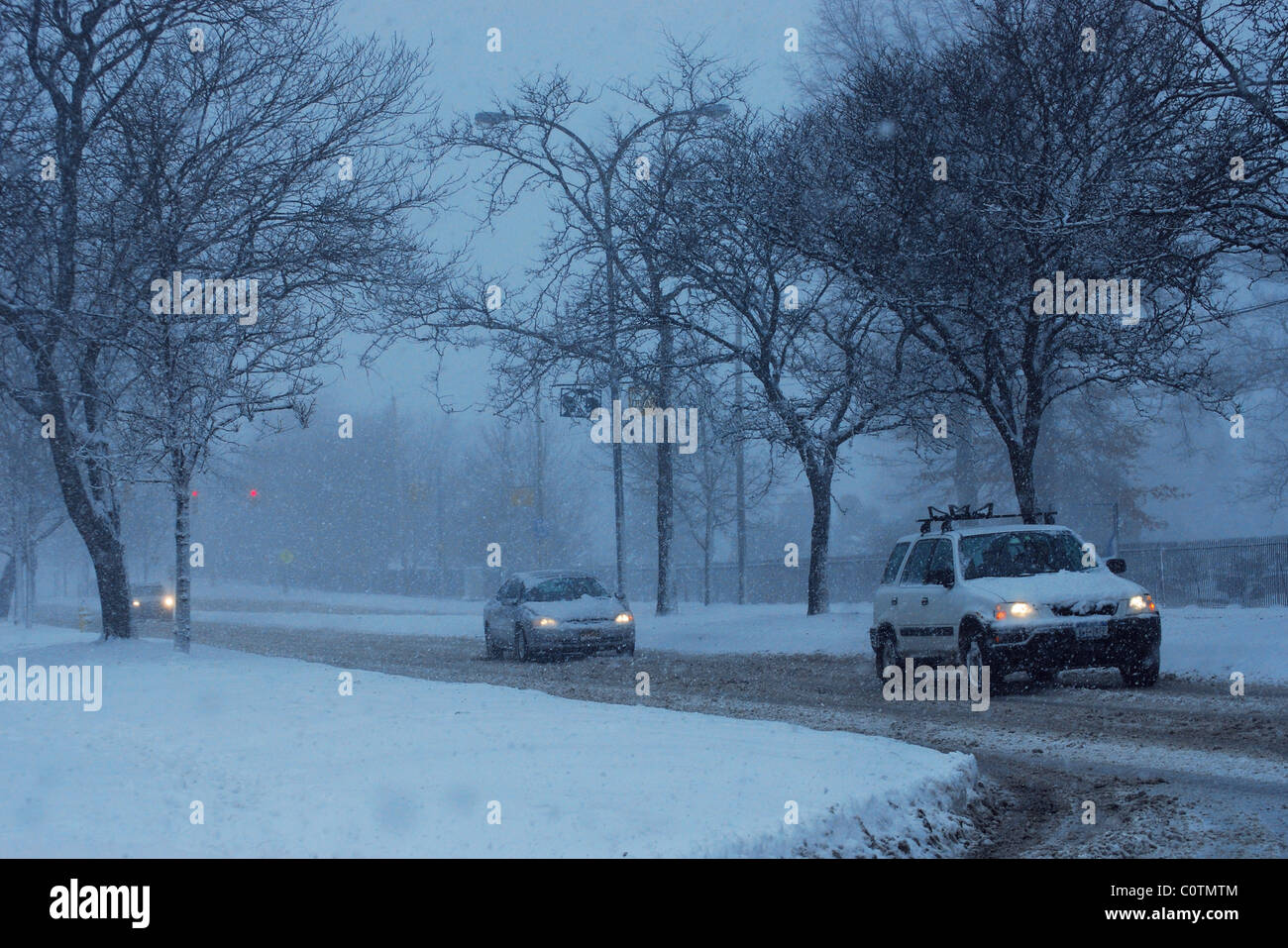 Autos bewegen sich langsam auf eisigem Schnee Weg. Stockfoto