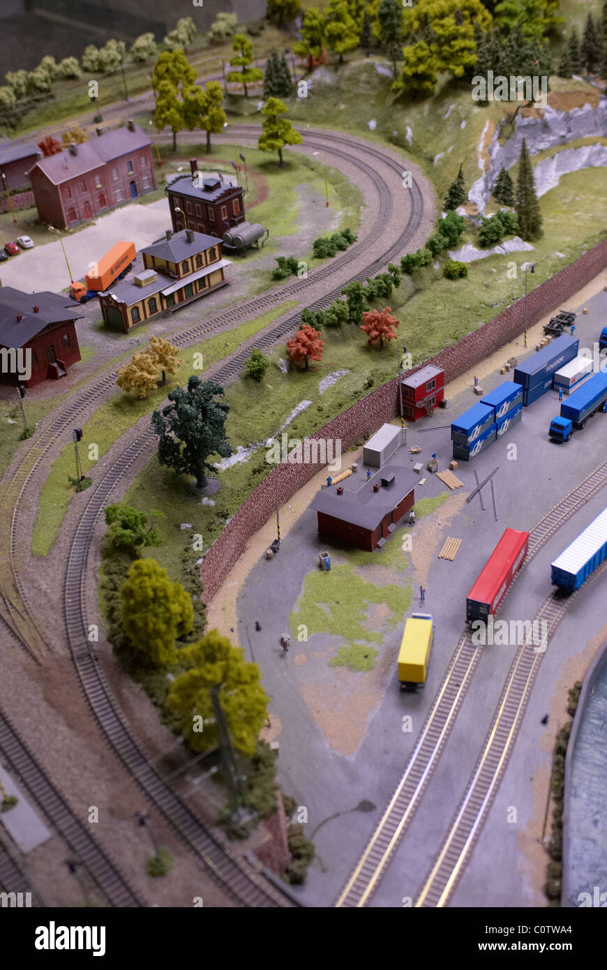 Detail des Modell Spielzeug Eisenbahn Bahnwerk mit Lok, Wagen, Gleise und Gebäude Stockfoto