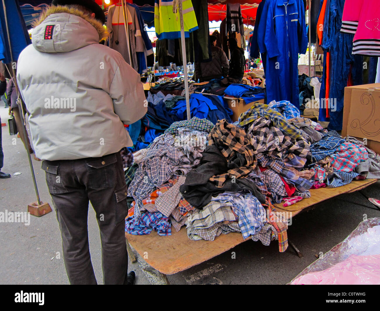 Paris, Frankreich, man Shopping, Rag Trade, billige gebrauchte Kleidung in Stapeln, im Verkauf, montreuil Flohmarkt, Winter Shopping Floh Stockfoto