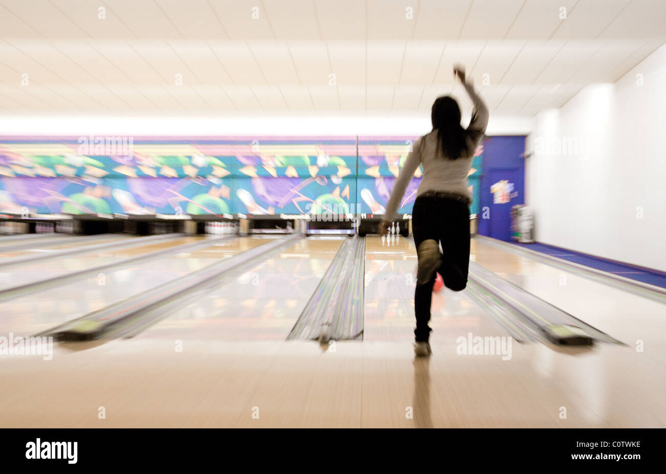 Eine junge Teen Teenager Frau Ten Pin bowling auf "Strikes" Bowling-Bahn, Ely, Großbritannien Stockfoto