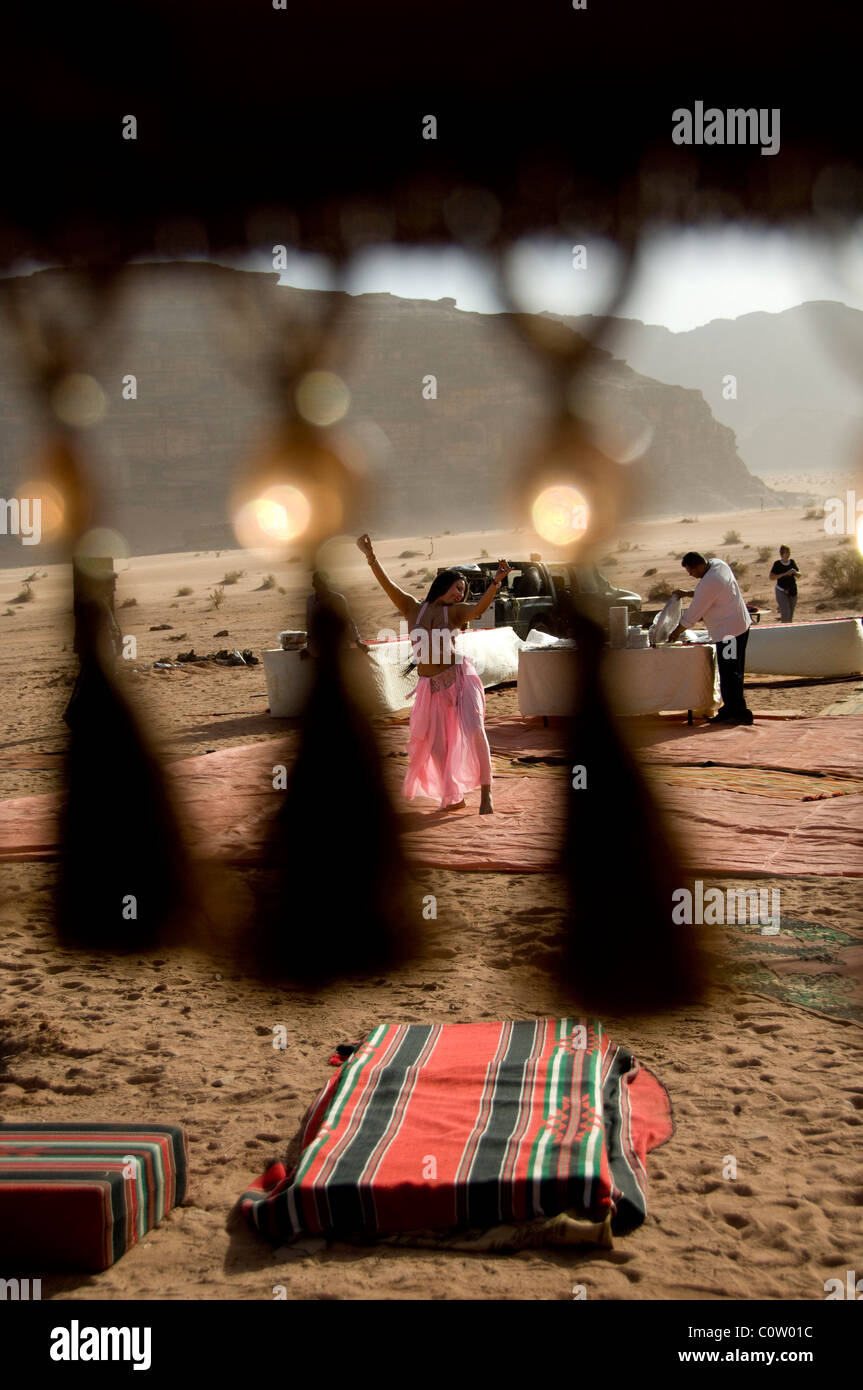 Jordan, Wadi Rum. Traditionellen Beduinen Zelt Abdeckung mit Perlen Quasten, Bauchtänzerin in Ferne inmitten der Wüste. Stockfoto