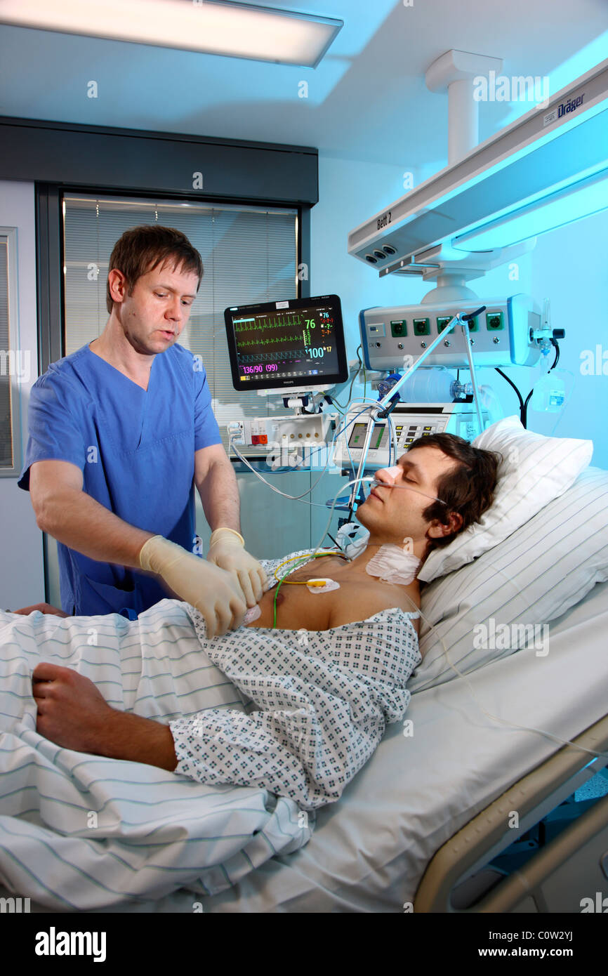 Intensivstation in einem Krankenhaus. Ein Patient wird mit verschiedenen lebenserhaltenden Systemen verbunden. Stockfoto