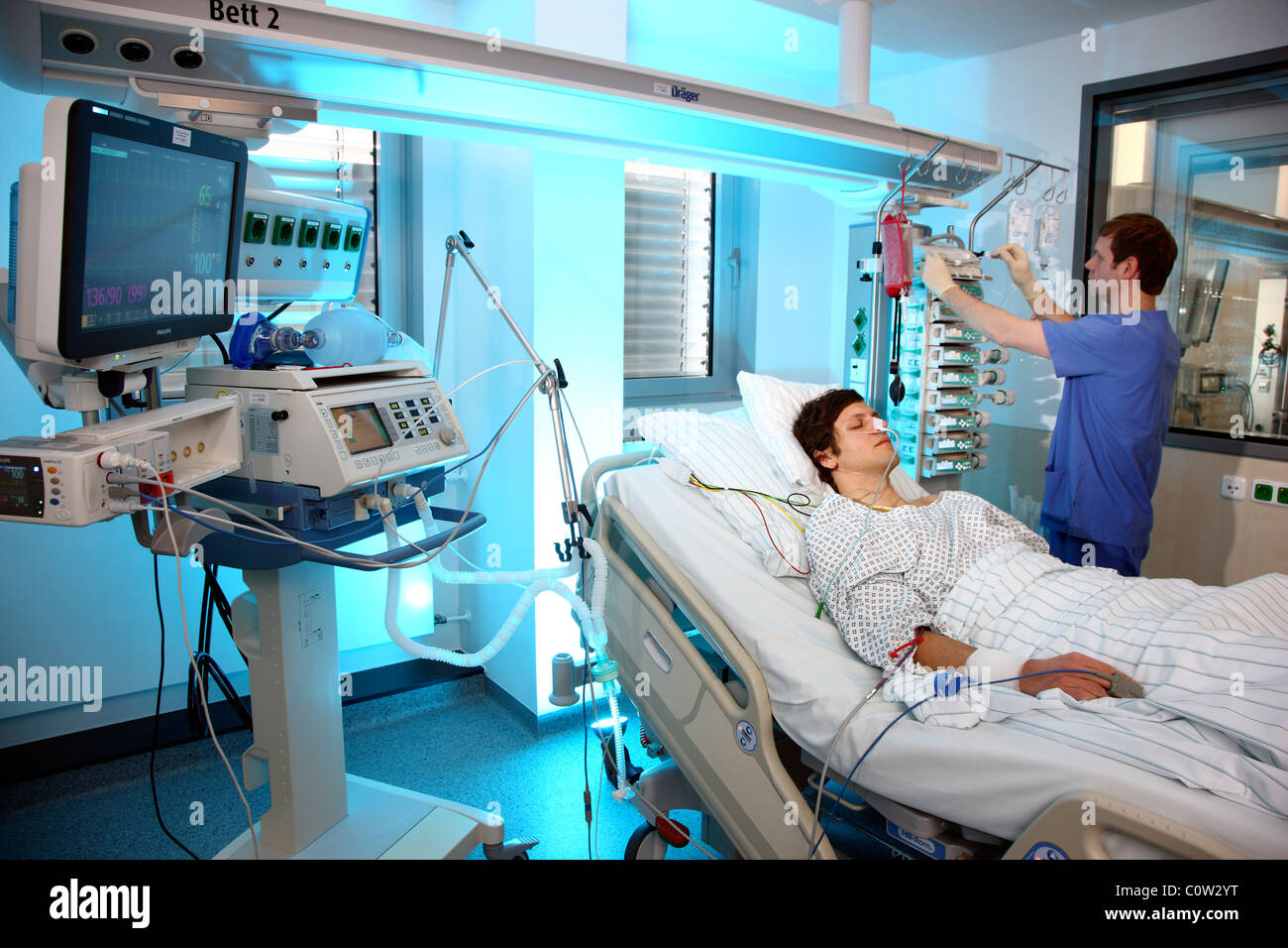 Intensivstation in einem Krankenhaus. Ein Patient wird mit verschiedenen lebenserhaltenden Systemen verbunden. Stockfoto