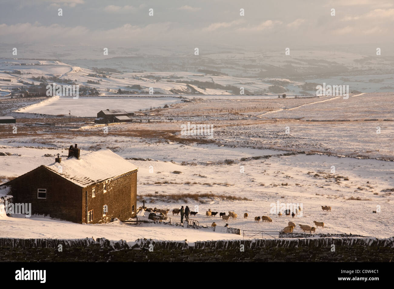 Landwirte und Schafen durch Bauernhaus in winterlichen Pennine hills Stockfoto