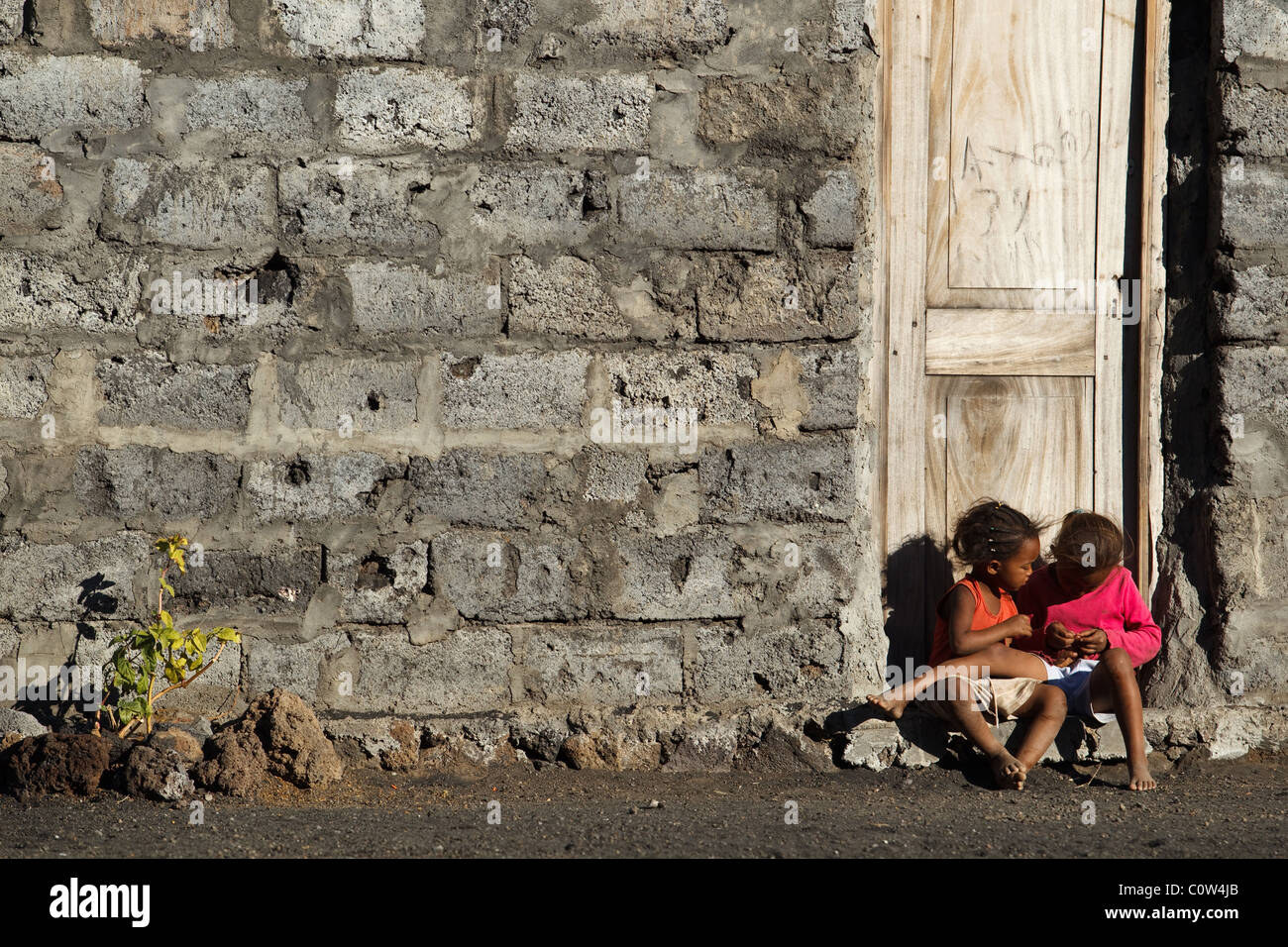 Kinder sitzen vor der Tür eines Hauses in Cha de Caldeiras, Fogo Island, Cape Verde auf Mittwoch, 5. Januar 2011. Stockfoto