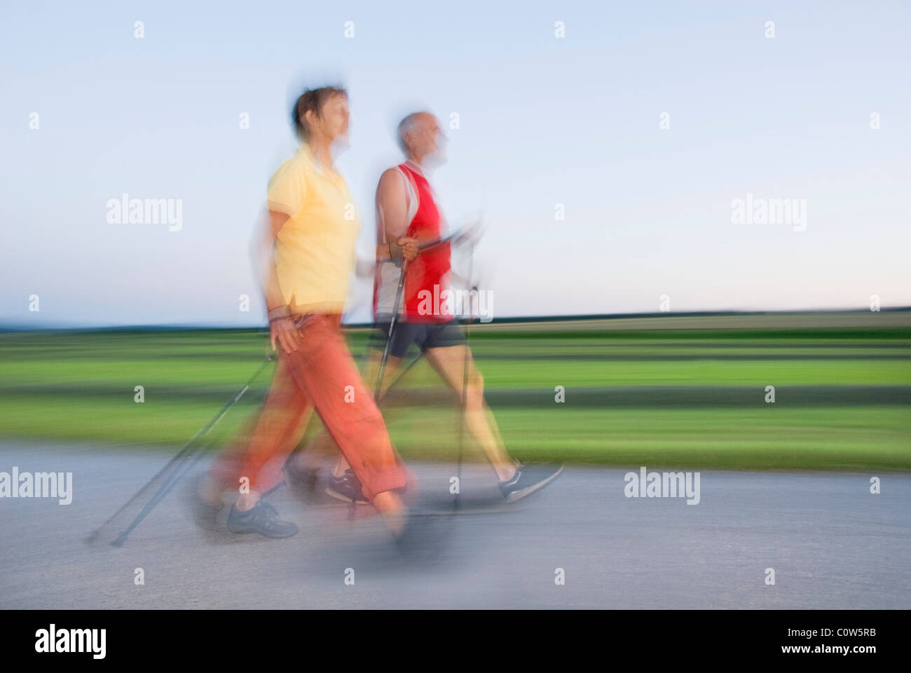 Ältere Frau und Mann zu Fuß, Nordic-walking, Bewegungsunschärfe, Waldviertler Region, Niederösterreich, Österreich Stockfoto