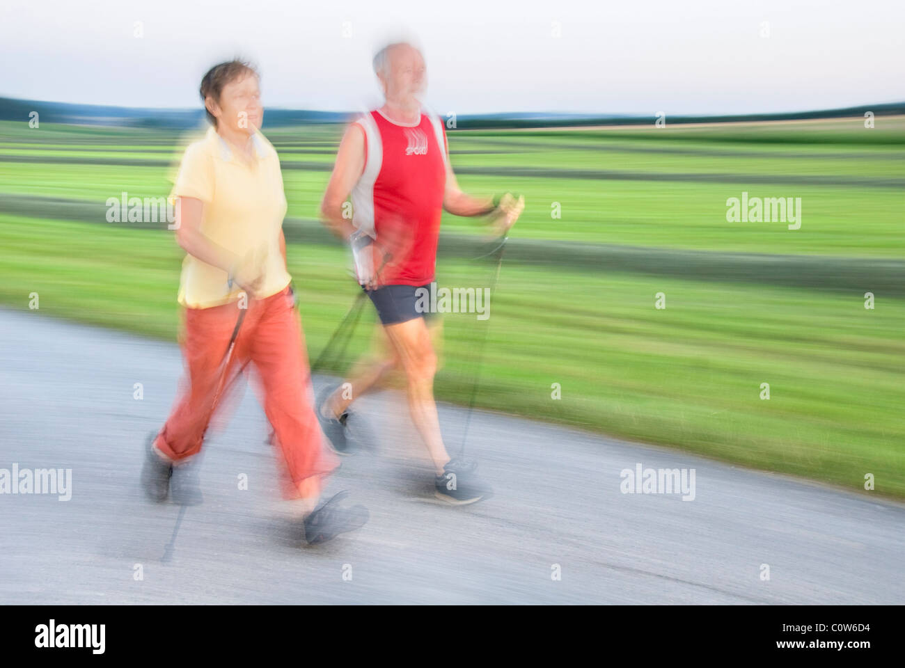 Ältere Frau und Mann zu Fuß, Nordic-walking, Bewegungsunschärfe, Waldviertler Region, Niederösterreich, Österreich Stockfoto