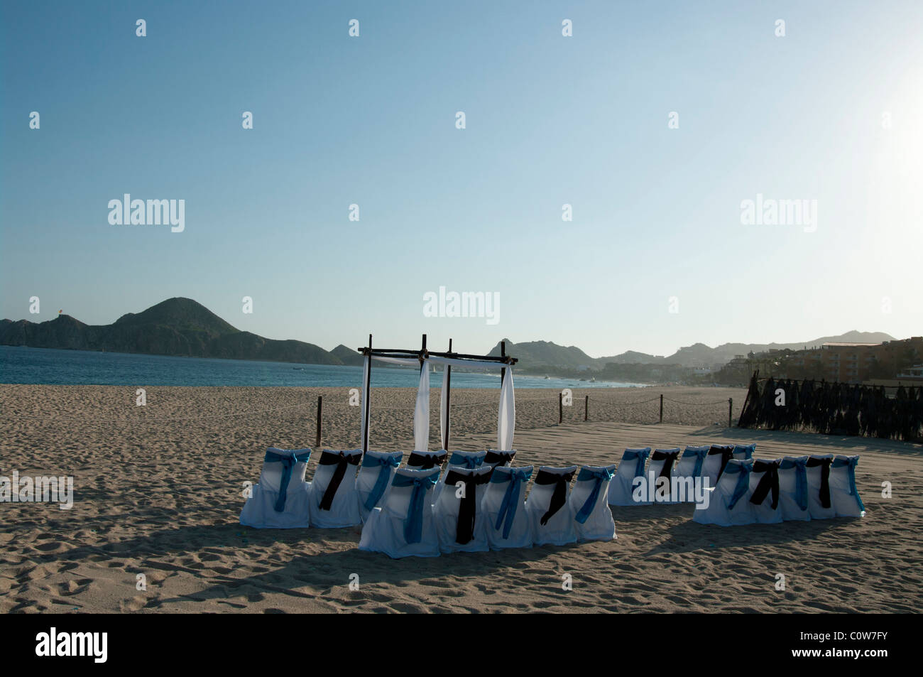 Stühlen und einem Bogen Hochzeit richten Sie an einem Strand warten auf Gäste und die Braut und der Bräutigam ankommen. Stockfoto