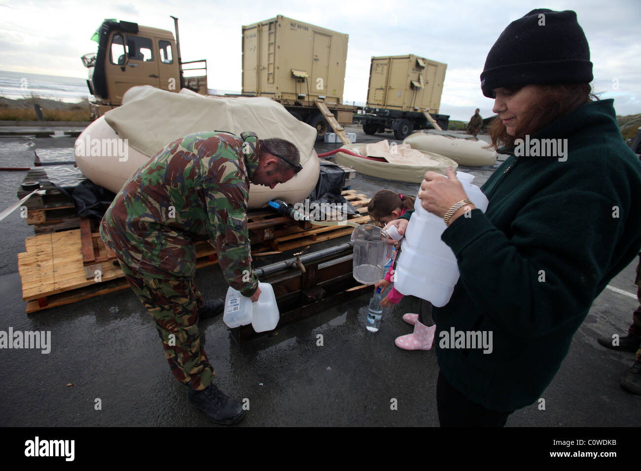 Einwohner von New Brighton, Christchurch, an der NZ Defence Force Entsalzung Einheit nach dem Erdbeben der Stärke 6,3 Stockfoto